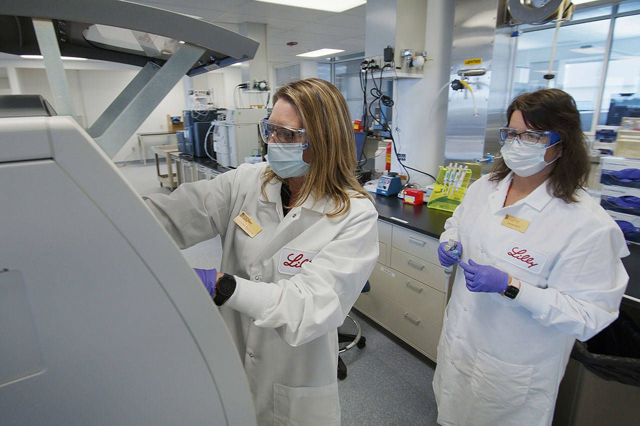 In this May 2020 photo provided by Eli Lilly, researchers prepare cells to produce possible COVID-19 antibodies for testing in a laboratory in Indianapolis. Antibodies are proteins the body makes when an infection occurs; they attach to a virus and help it be eliminated. (David Morrison/Eli Lilly via AP)