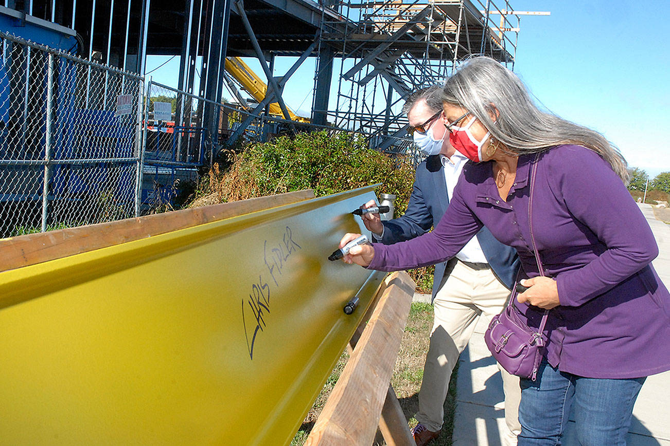 Signing the final Field Arts & Events Hall beam