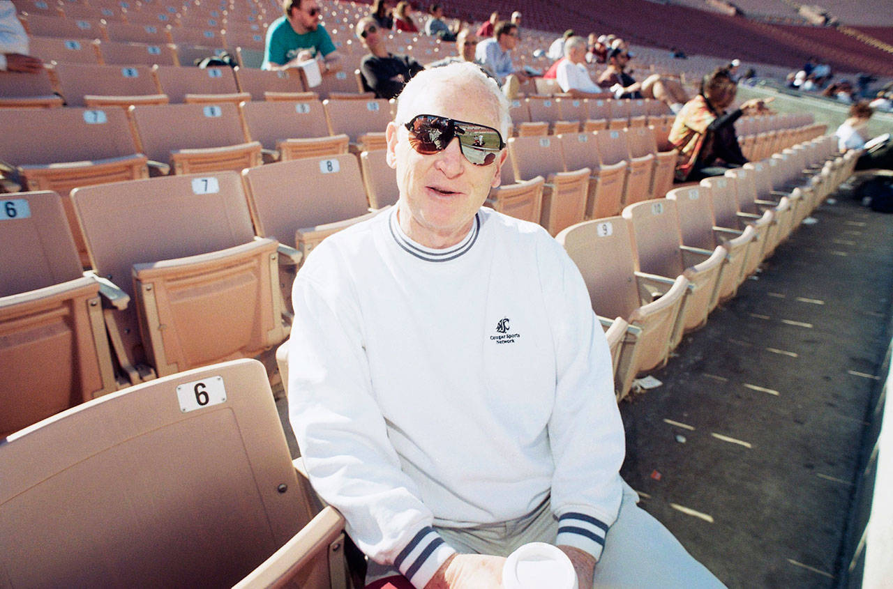 Washington State football announcer Bob Robertson watches team practice from stands at the Los Angeles Coliseum on Dec. 27, 1997. The longtime sports announcer will broadcast from Pasadena on New Years Day when Washington State will take on the University of Michigan in the Rose Bowl. (Gerard Burkhart/Associated Press)