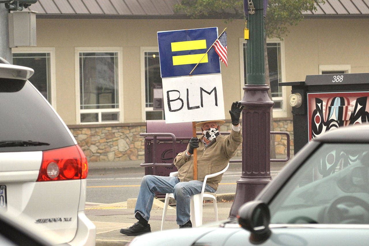 Neil Morris said he felt he missed out advocating for civil rights in the 1960s while serving in the US Navy, so now he’s continued a streak of standing or sitting on the Sequim Avenue/Washington Street intersection holding Black Lives Matter and Human Rights Campaign signs. (Matthew Nash/Olympic Peninsula News Group)