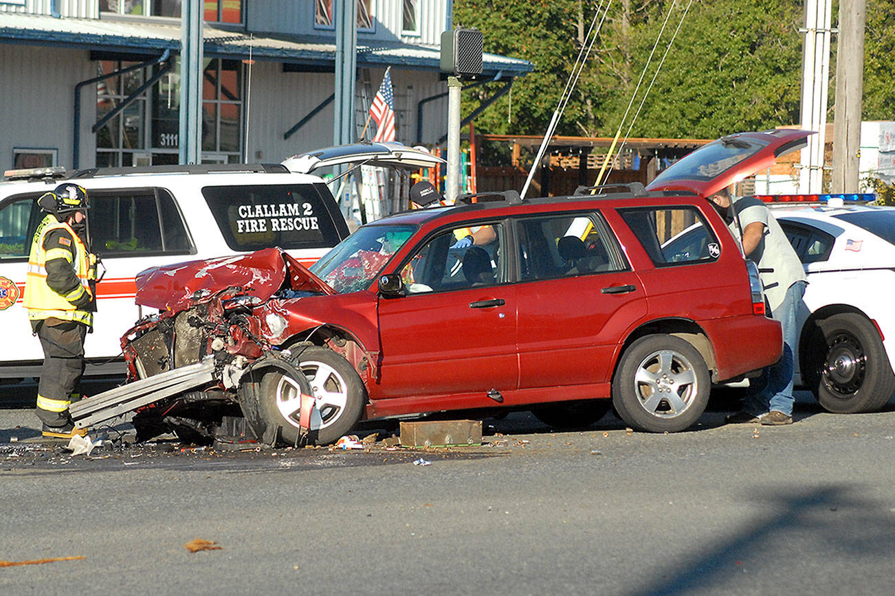 Keith Thorpe/Peninsula Daily NewsRescue workers attend to one of several vehicles involved in a collision at U.S. Highway 101 and North Larch Avenue east of Port Angeles on Tuesday afternoon that snarled westbound traffic.