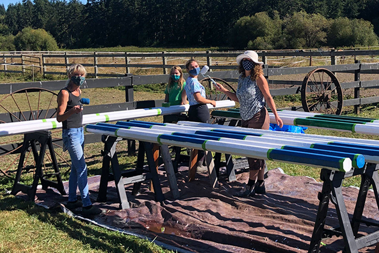 Equitese Pony Club members, from left, Maria Timmons, Molly Lance, Hailey Gallagher, Kimberly Gallagher and Philippa Lance paint new poles to jump over at the Heron Pond Farm Equestrian Center in Port Townsend. The club held a fundraising  car wash last summer so they could purchase the materials needed to update, rebuild and build new poles and other jumping equipment. (Christine Headley)