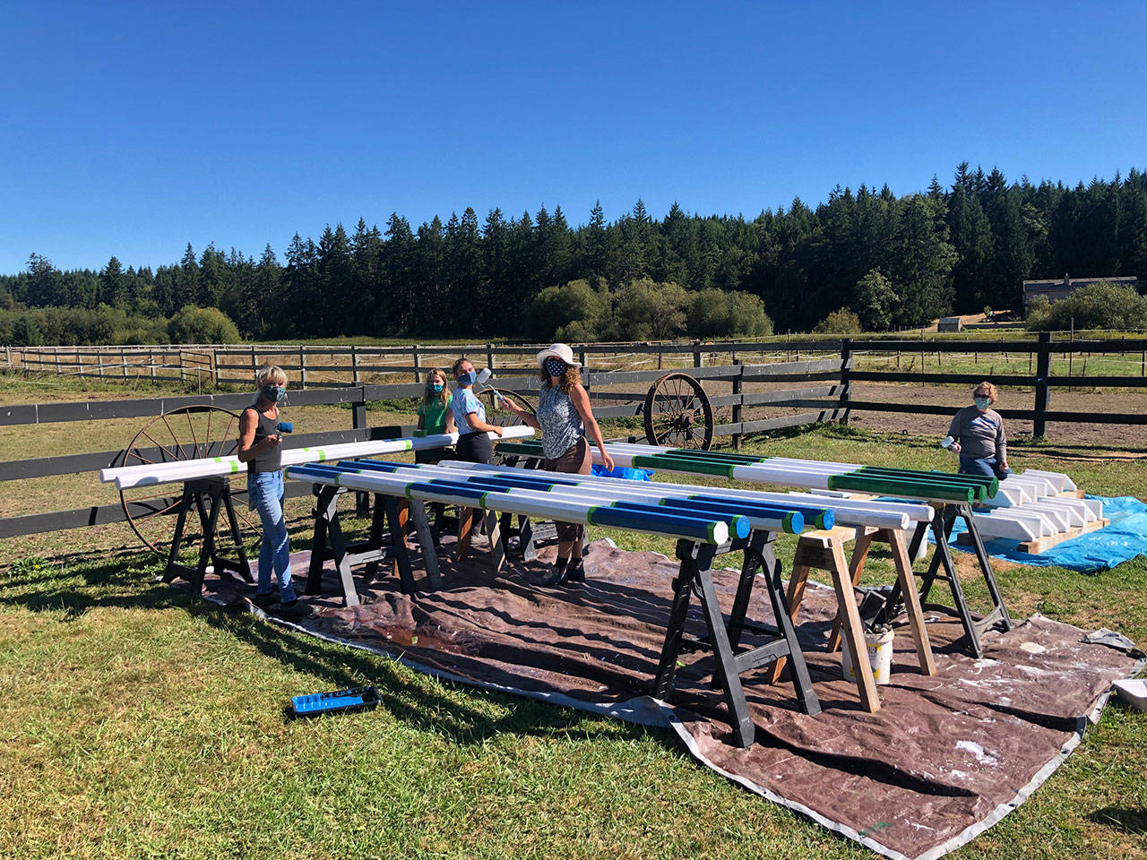 Equitese Pony Club members, from left, Maria Timmons, Molly Lance, Hailey Gallagher, Kimberly Gallagher and Philippa Lance paint new poles to jump over at the Heron Pond Farm Equestrian Center in Port Townsend. The club held a fundraising car wash last summer so they could purchase the materials needed to update, rebuild and build new poles and other jumping equipment. (Christine Headley)