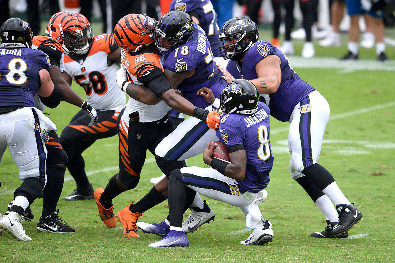 Cincinnati Bengals defensive end Carlos Dunlap (96) is able to sack Baltimore Ravens quarterback Lamar Jackson (8) in spite of being blocked by Ravens offensive tackle Orlando Brown (78) during the first half of an NFL football game Sunday, Oct. 11, 2020, in Baltimore. (Nick Wass/Associated Press)