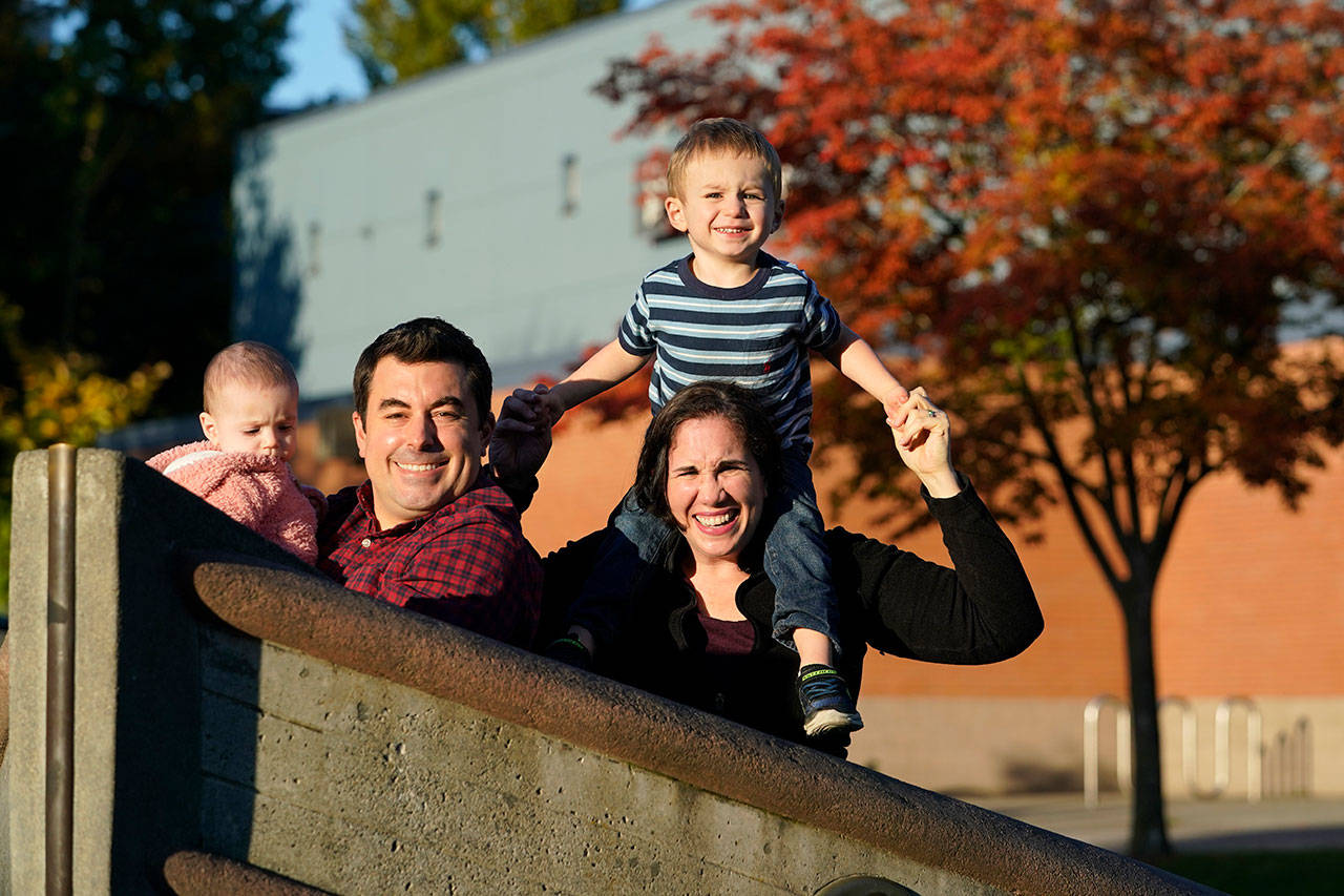 Parents Joelle and Ryan Wheatley pose with their children Anna, 9 months, and Jacob, 2, for a photo Wednesday, Oct. 21, 2020, in Seattle. As with other families, they are dealing with stricter daycare rules on possible coronavirus symptoms that feel incompatible with the germy reality of modern childhood, where a toddler’s sniffle or cough could bring 10 days of quarantine. (Elaine Thompson/Associated Press)