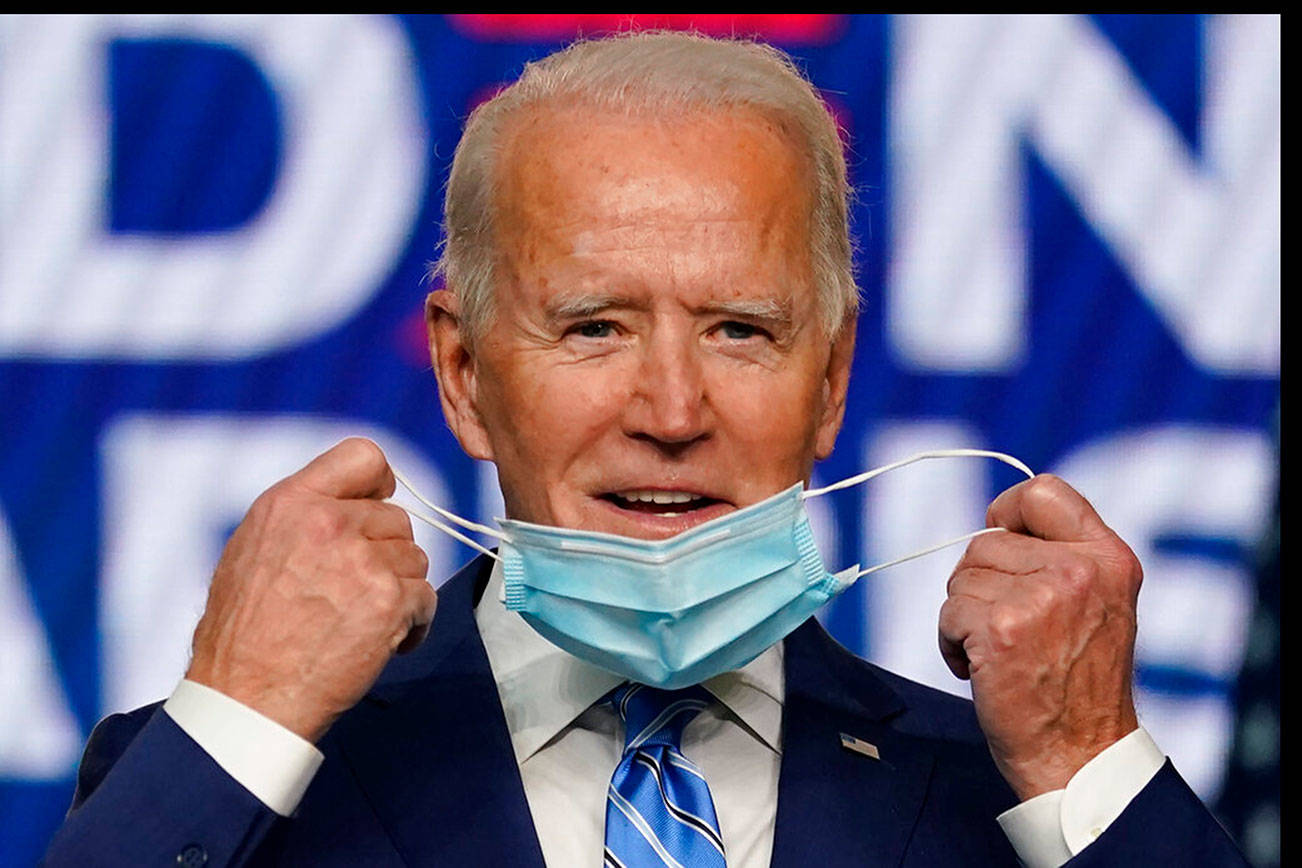 Democratic presidential candidate former Vice President Joe Biden takes off his face mask as he arrives to speak, Wednesday, Nov. 4, 2020, in Wilmington, Del. (AP Photo/Carolyn Kaster)