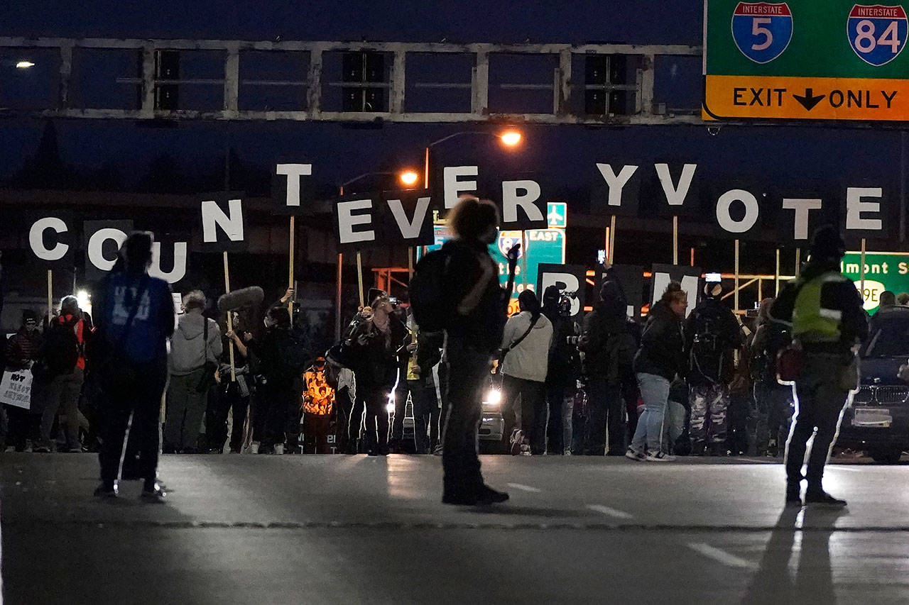 Protesters hold letters that spell Count Every Vote as they cross an overpass while marching in Portland, Ore., on Wednesday, Nov. 4, 2020, following Tuesday’s election. (Marcio Jose Sanchez/Associated Press)