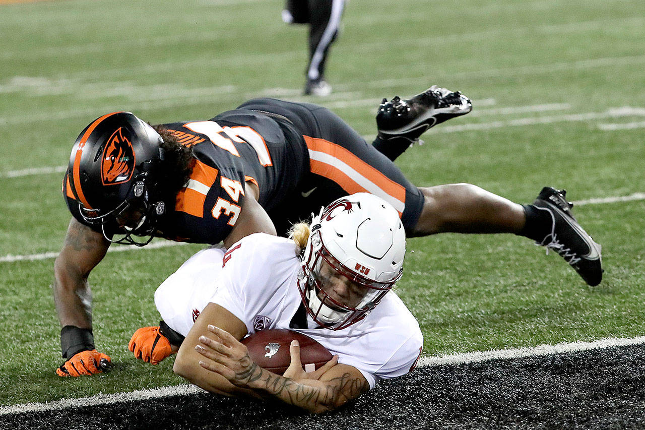 Washington State quarterback Jayden de Laura slides into the end zone, under Oregon State inside linebacker Avery Roberts (34) on Saturday in Corvallis, Ore., Saturday. Washington State won 38-28. (Amanda Loman/The Associated Press)