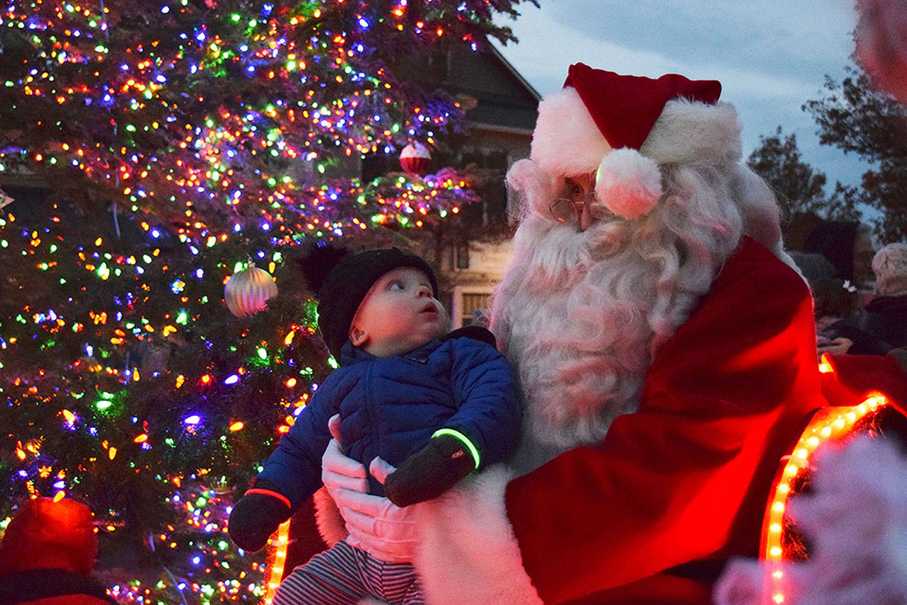 Magic moments like this between Dylan Krashan and Santa Claus in 2018 won't happen this year at the downtown Sequim tree lighting event due to pandemic protocols coming into place. The tree lighting moves online to 5 p.m. on Thanksgiving at the Sequim-Dungeness Valley Chamber of Commerce's website and social media pages. Sequim Gazette file photo by Erin Hawkins