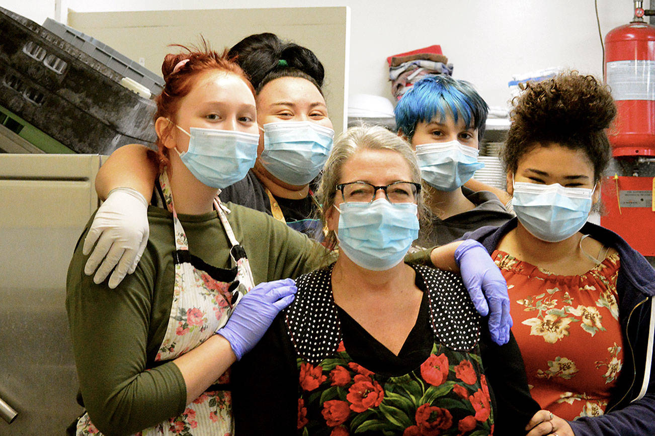 Working on Thanksgiving in the Tri-Area Community Center kitchen are Anita Schmucker, center, and her foster kids, from left, Mya, Rosemary, Friday and Sadie. The family helped prepare some 300 dinners at the Chimacum center Thursday. (Diane Urbani de la Paz/Peninsula Daily News)