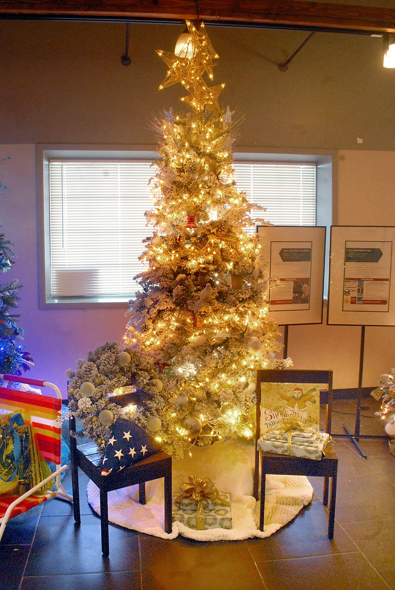 A Christmas tree titled “Star Way to Living” stands on display at Edna’s Place in Port Angeles on Saturday after fetching the top bid during Friday night’s Festival of Trees gala and auction. The tree, sponsored by First Federal, includes a collection of premiums themed after the Captain Joseph House. The tree received a bid of $6,500 to benefit the Olympic Medical Center Foundation. (Keith Thorpe/Peninsula Daily News)