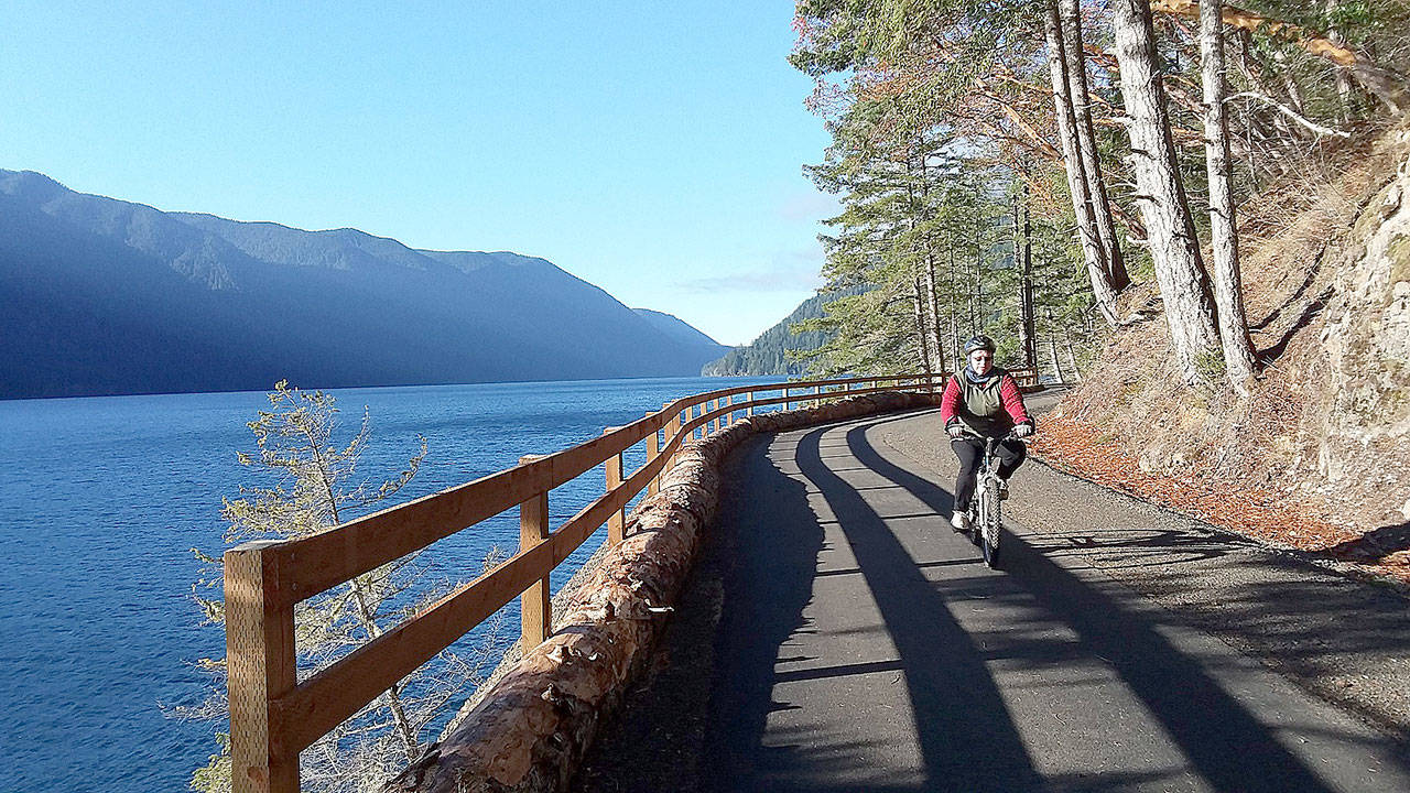 Bicyclists and hikers enjoyed beautiful weather at the new Spruce Railroad Trail on Wednesday on the north shore of Crescent Lake. Here a cyclist rides on the trail just west of the Daley Rankin Tunnel. (Pierre LaBossiere/Peninsula Daily News)