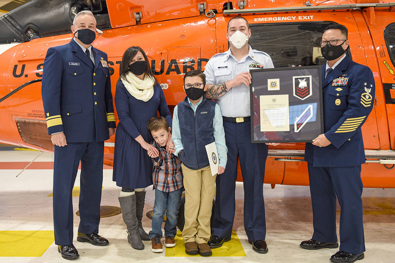 From left to right, Rear Adm. Jack Vogt, Kelly Graham, Caleb Graham, Cohen Graham, Boatswains Mate 1st Class Markus Graham and Master Chief Petty Officer Jason Wong. (Petty Officer 2nd Steve Strohmaier/U.S. Coast Guard, 13th District)