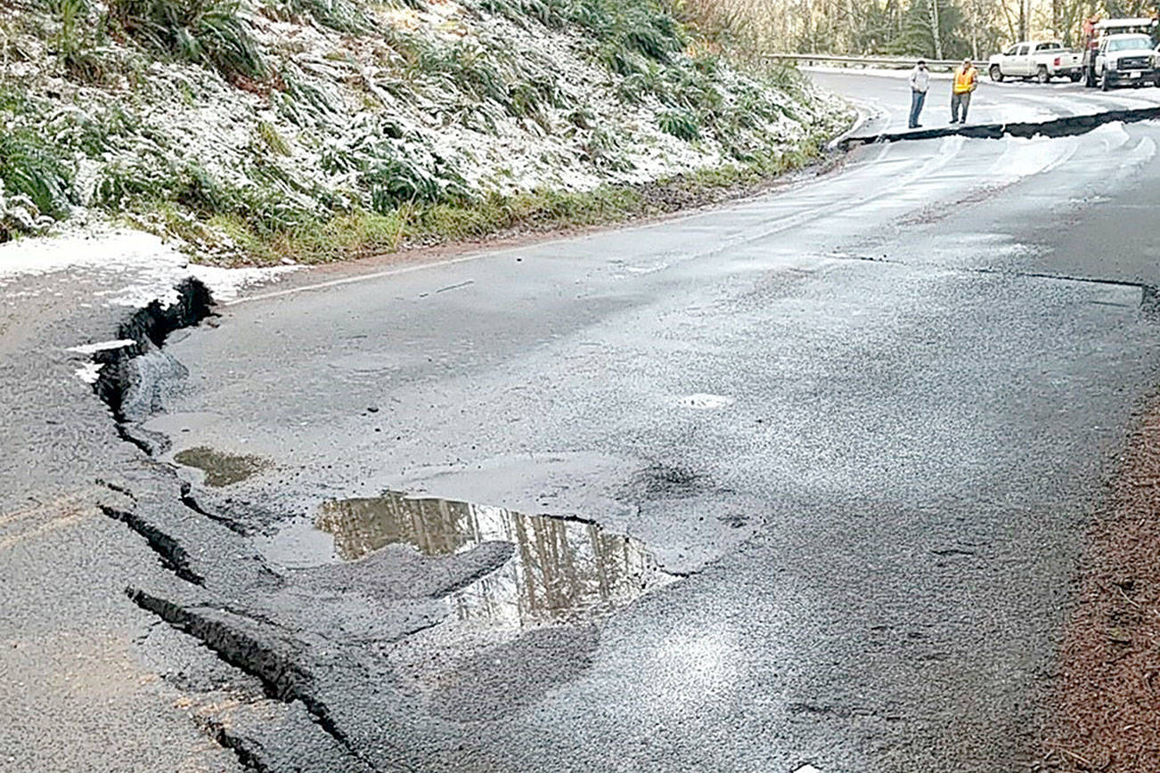 State Department of Transportation crews inspect a sunken section of state Highway 112.