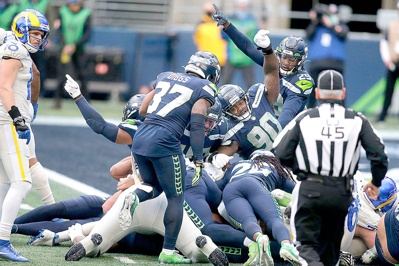 Seattle Seahawks players, including defensive tackle Jarran Reed (90) react  after the Seahawks …