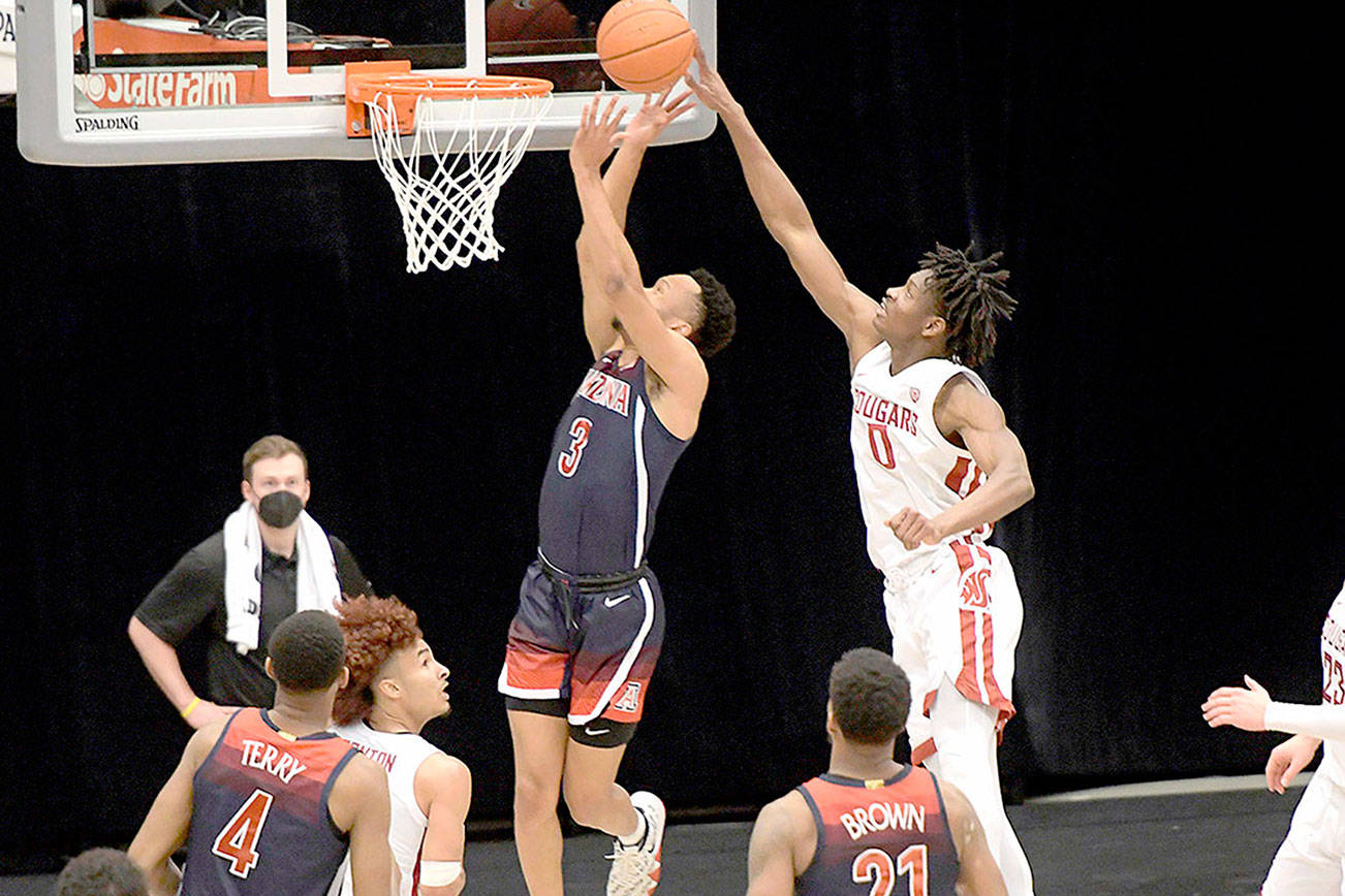 Washington State center Efe Abogidi (0) blocks a shot by Arizona guard Jemarl Baker Jr. (3) in the first half of an NCAA college basketball game on Saturday in Pullman. (Dean Hare/The Associated Press)