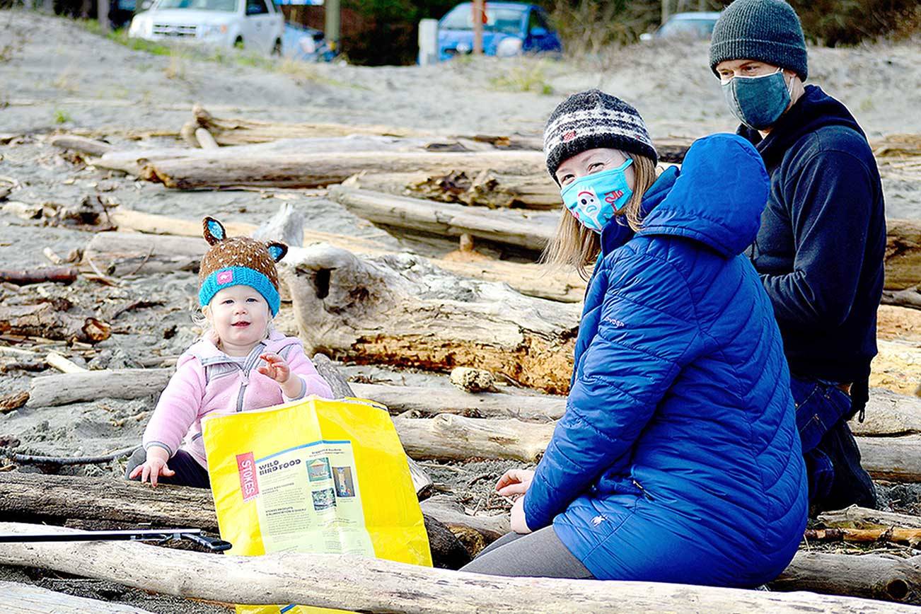 Eowyn Reardon, 22 months, assisted parents Benjamin Reardon and Amy Johnson of Port Townsend at the Martin Luther King Jr. Day beach cleanup on Monday. Scores of people took to the shores at Fort Worden State Park for the event hosted by the Port Townsend Marine Science Center. (Diane Urbani de la Paz/Peninsula Daily News)