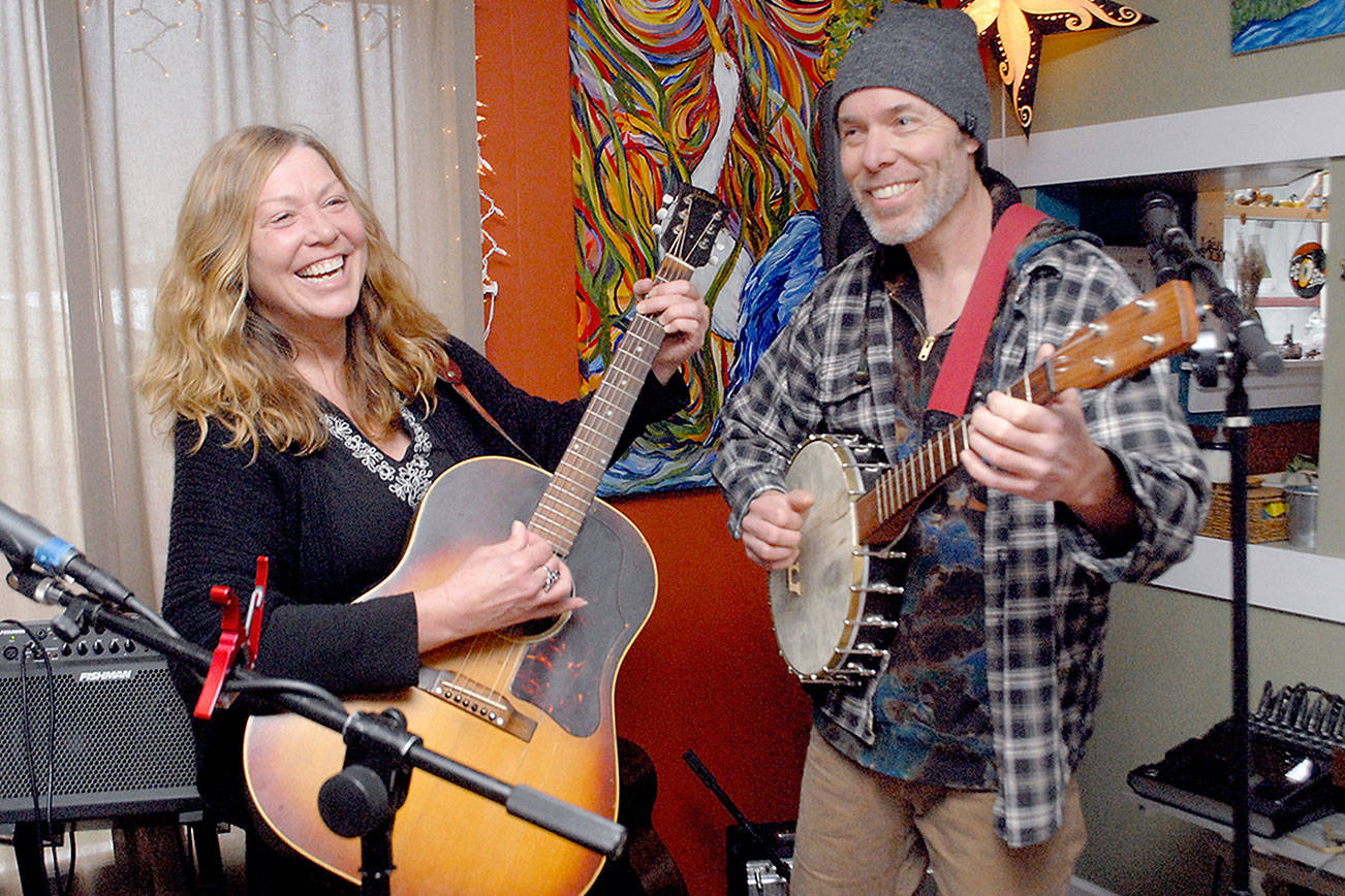 Kim Trenerry and Jason Mogi, who perform as Deadwood Revival, practice in their Port Angeles home on Thursday in preparation for a live-streamed concert for the Juan de Fuca Foundation's Winter Benefit on Saturday night. (Keith Thorpe/Peninsula Daily News)