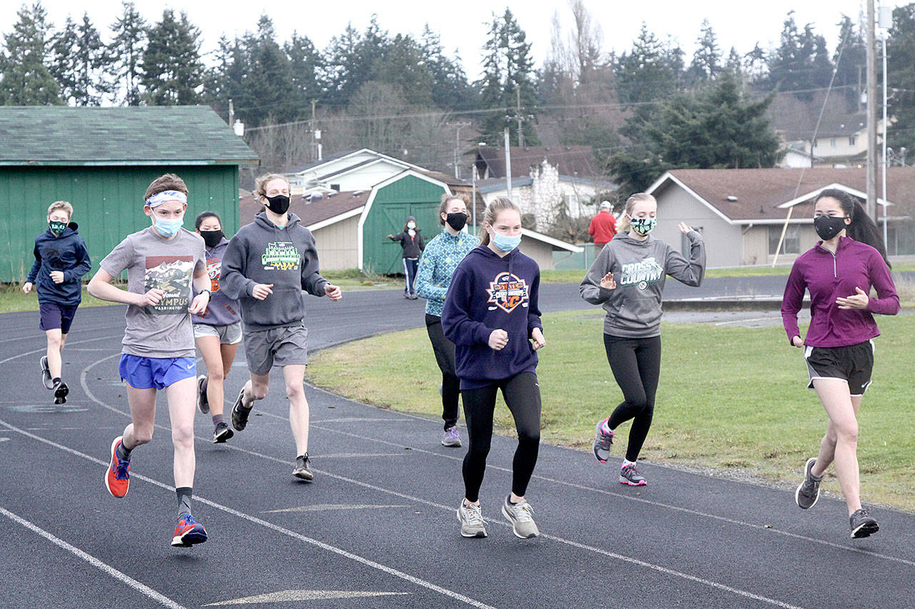 Dave Logan/for Peninsula Daily News Port Angeles Roughrider cross country runners begin practicing Monday at the Port Angeles High School track. The first cross country meets are scheduled Saturday as prep sports slowly return to the Olympic Peninsula. Only cross country can begin competing at the moment but other sports are practicing in hopes of beginning in mid-February.