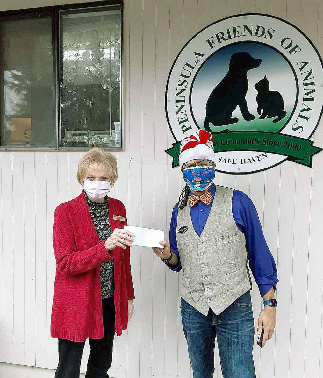 Peninsula Friends of Animals donation Peninsula Friends of Animals Executive Director Danette Grady, left, receives a donation of $150 for the cage-free, no-kill animal welfare group from Tyrone Beatty, the assistant manager of the Port Angeles branch of First Security Bank. (Courtesy photo)