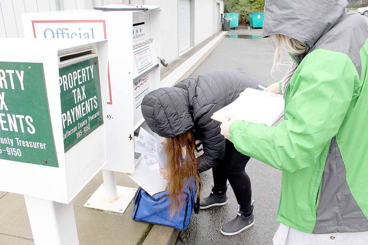 Jefferson County Voter Registration Coordinator Sandi Eldridge, left, and Election Coordinator Quinn Grewell collect ballots in the rain Thursday morning from the dropbox behind the Jefferson County Courthouse. Residents voting in the Feb. 9 special election have until 8 p.m. Tuesday to return their ballot to an official election dropbox. (Zach Jablonski/Peninsula Daily News)