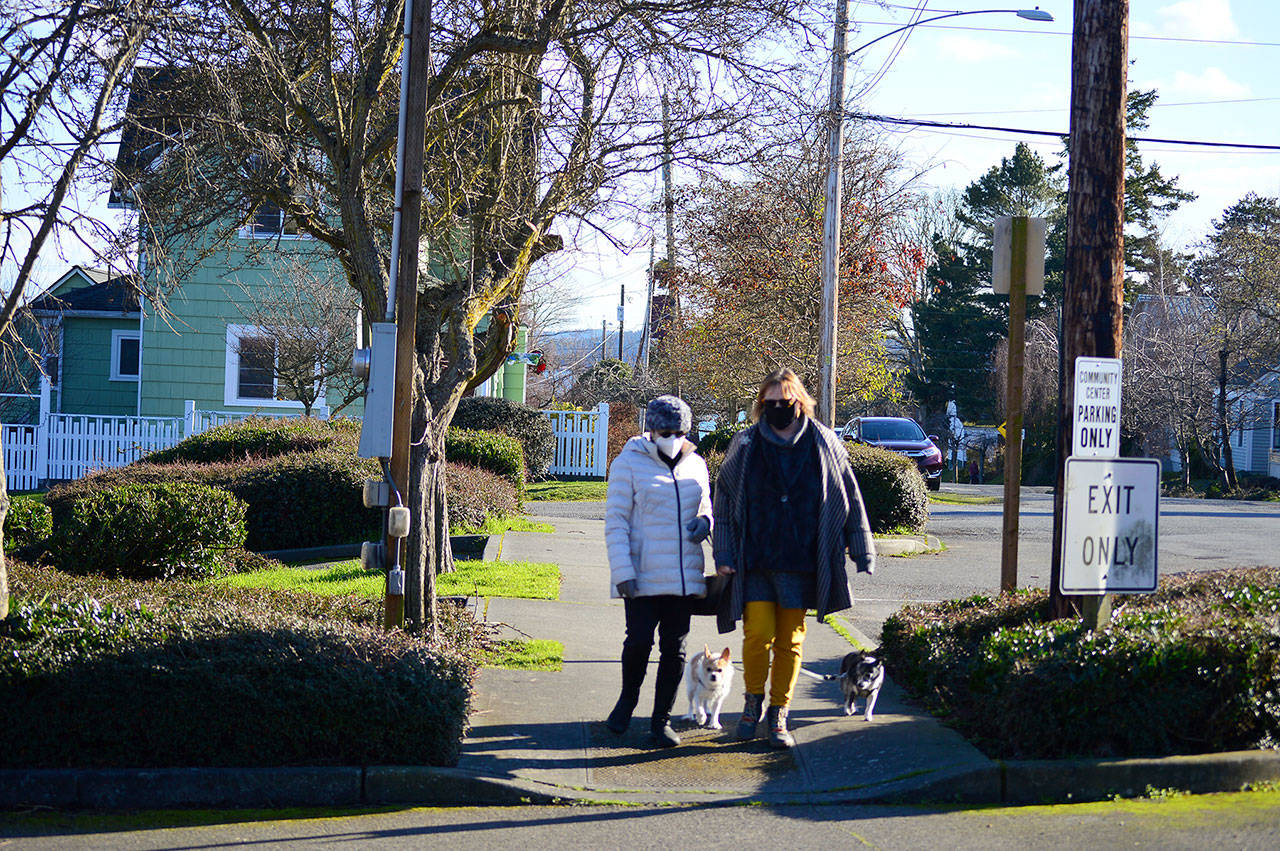 Pam Chapman, left, and neighbor Corena Stern, along with Chapman’s dogs Bella and Hamish, walk on Tyler Street in Uptown Port Townsend on Tuesday. Port Townsend officials are looking at ways to maintain 81 miles of city streets on a limited budget. (Diane Urbani de la Paz/Peninsula Daily News)