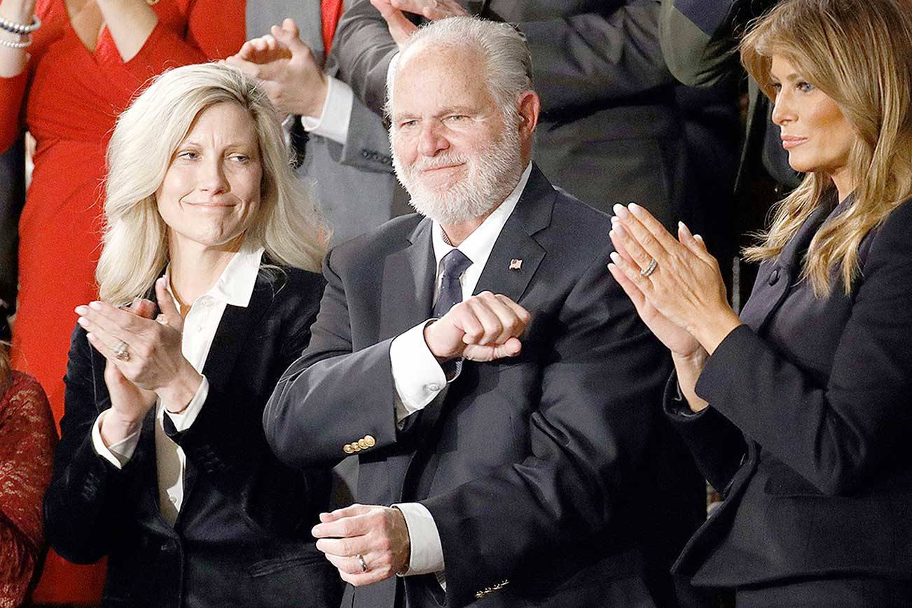 FILE - In this Feb. 4, 2020 file photo, Rush Limbaugh reacts as first Lady Melania Trump, and his wife Kathryn, applaud, as President Donald Trump delivers his State of the Union address to a joint session of Congress on Capitol Hill in Washington.  Limbaugh, the talk radio host who became the voice of American conservatism, has died. (AP Photo/Patrick Semansky, File)