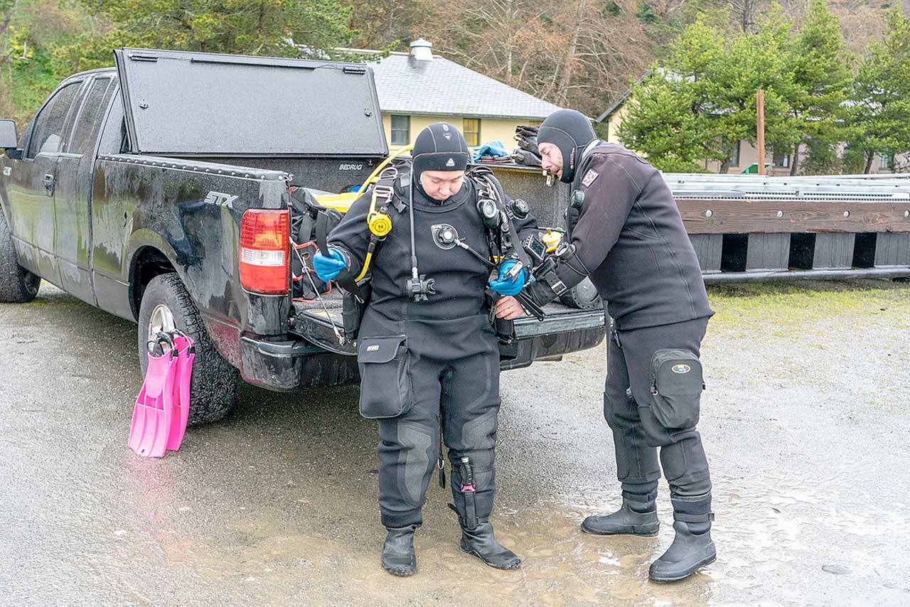 Matt Peaverly of Portland, Ore., helps his wife Grace with her dive gear before they go diving at the Marine Science Center at Fort Worden State Park on Monday. The couple, along with another diver, went diving at various sites during the weekend. (Steve Mullensky/for Peninsula Daily News)