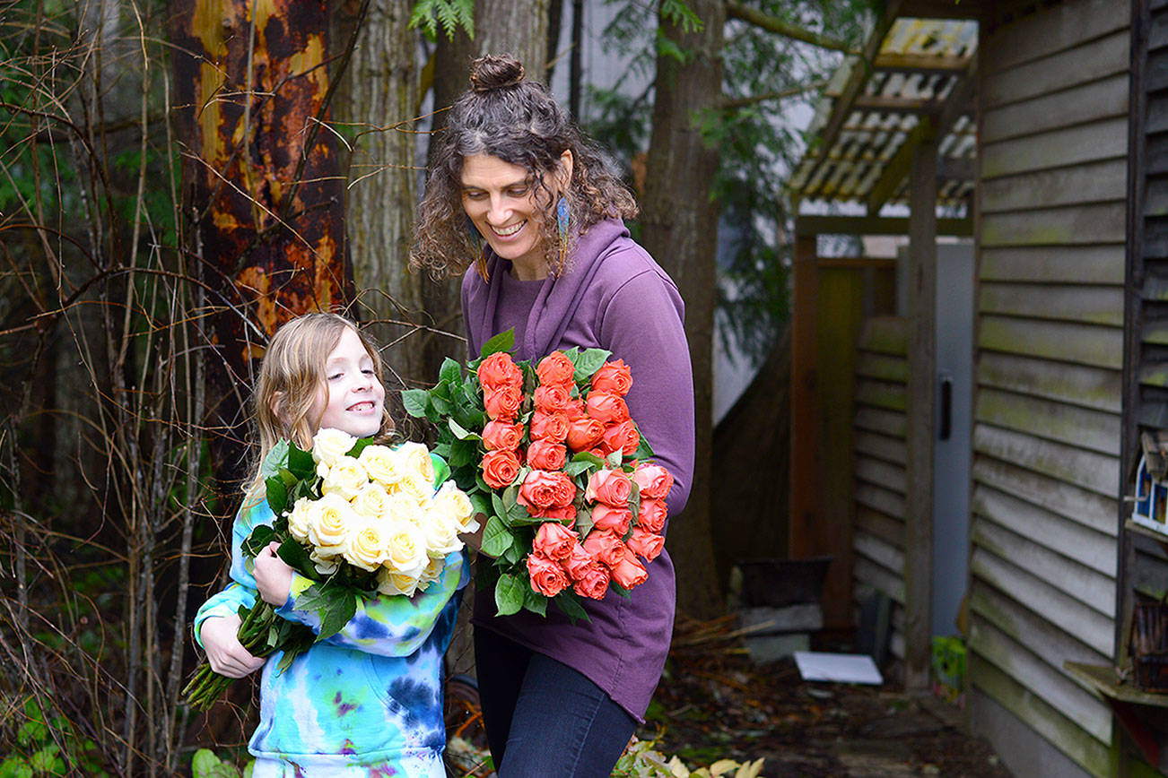 Farmer-florist Lexi Koch of Port Townsend and her son Jude, 8, unwrapped a few dozen roses Thursday for the extra-large floral heart garland to be placed at Haller Fountain on Monday. (Diane Urbani de la Paz/Peninsula Daily News)