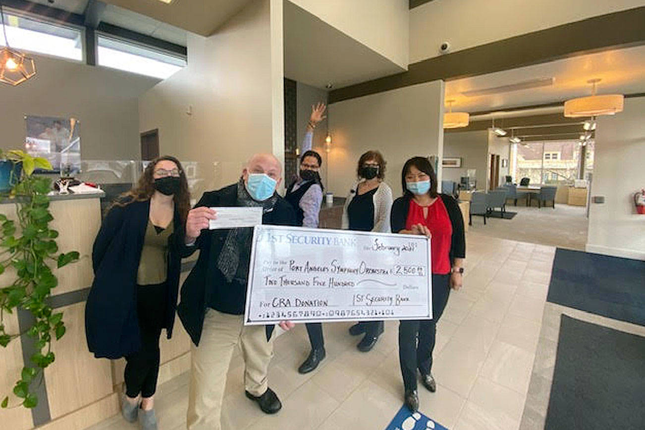 Port Angeles Symphony conductor and music director Jonathan Pasternack, foreground, accepted a major donation for the Adventures in Music program from 1st Security Bank earlier this month. With him at the Sequim branch are, from left, bank staff member Danielle Lorentzen, assistant manager Tyrone Beatty, branch manager Elisa Simonsen and personal banker Rui Starrett. photo courtesy Port Angeles Symphony