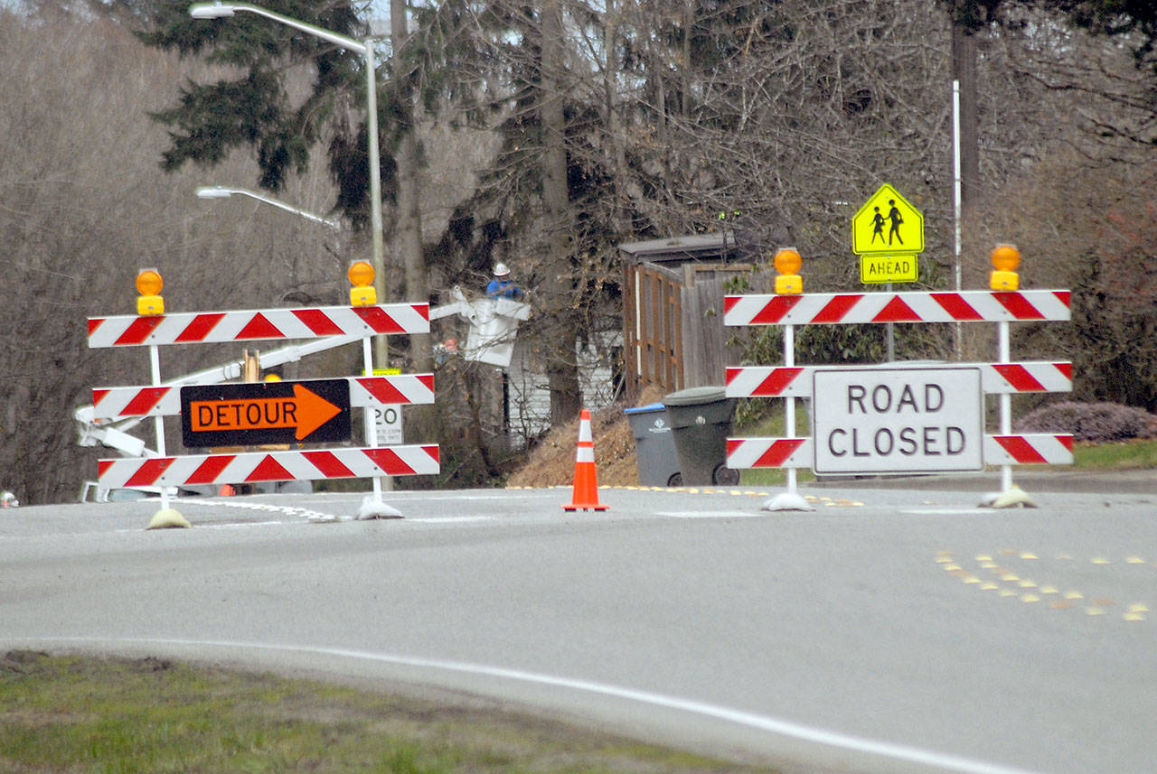 Barricades block a section of Race Street at Park Avenue in Port Angeles as a crew trims trees on Tuesday. (Keith Thorpe/Peninsula Daily News)