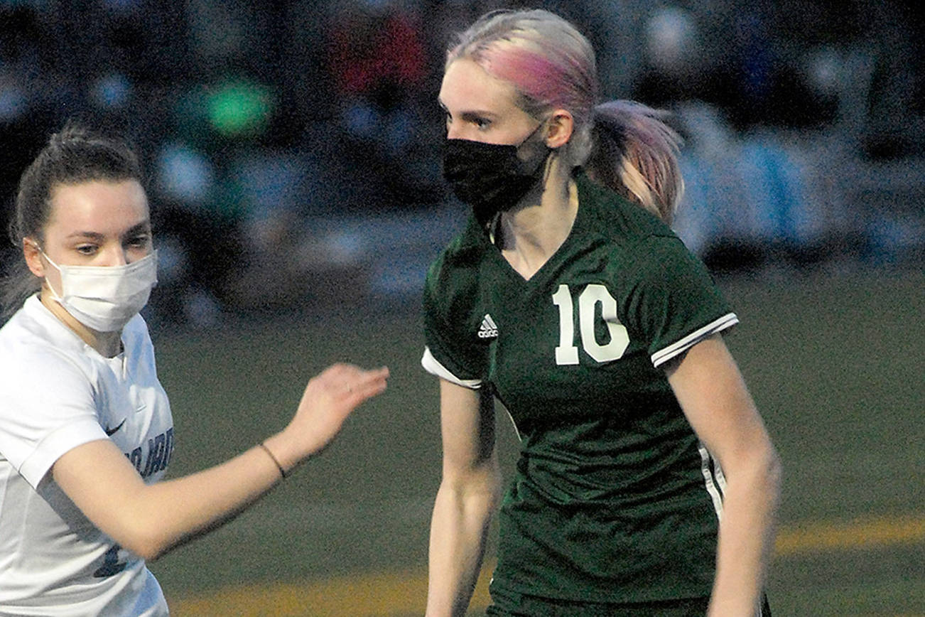 Keith Thorpe/Peninsula Daily News
Port Angeles' Millie Long, right, looks past the defense of Olympic's Claire Caldwell in the first half of Thursday night's match at Peninsula College in Port Angeles.