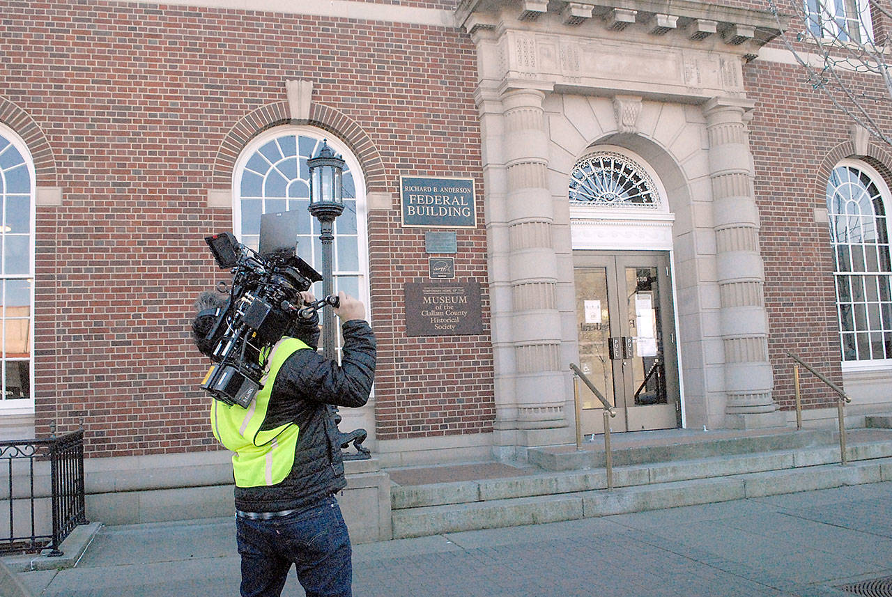 Videographer Paul Mailman of Santa Monica, Calif.,-based Furlined Commercial Production Co. films building exteriors of the Richard B. Anderson Federal Building in Port Angeles on Friday for an upcoming commercial for a cell phone service provider. The crew spent Friday afternoon taping scenes from around downtown and were scheduled to record a scene with live actors Saturday. (Keith Thorpe/Peninsula Daily News)