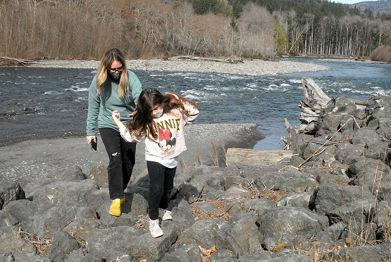 Rebecca Eller and her daughter, Bailey, 6, both of Fort Worth, Texas, pick their way through the rock along the bank of the Elwha River in Olympic National Park west of Port Angeles on Tuesday. They were returning from an excursion along the river’s edge. (Keith Thorpe/Peninsula Daily News)