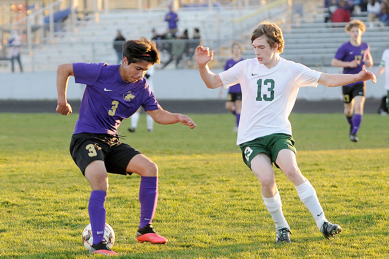 Sequim's Cristian Gonzalez, left, looks to make a move past Port Angeles' Josiah Long in the Wolves' 2-0 home-opener win over the Roughriders on March 25. 
Michael Dashiell/Olympic Peninsula News Group