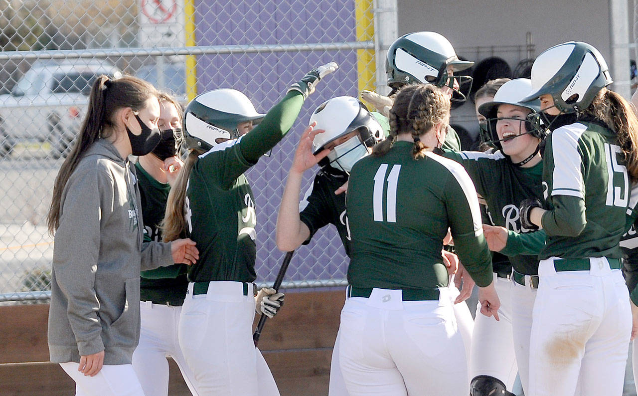 Port Angeles teammates congratulate Natalie Robinson, center in mask, after her three-run home run in the fifth inning helped the Roughriders beat the Sequim Wolves 11-6. (Michael Dashiell/Olympic Peninsula News Group)