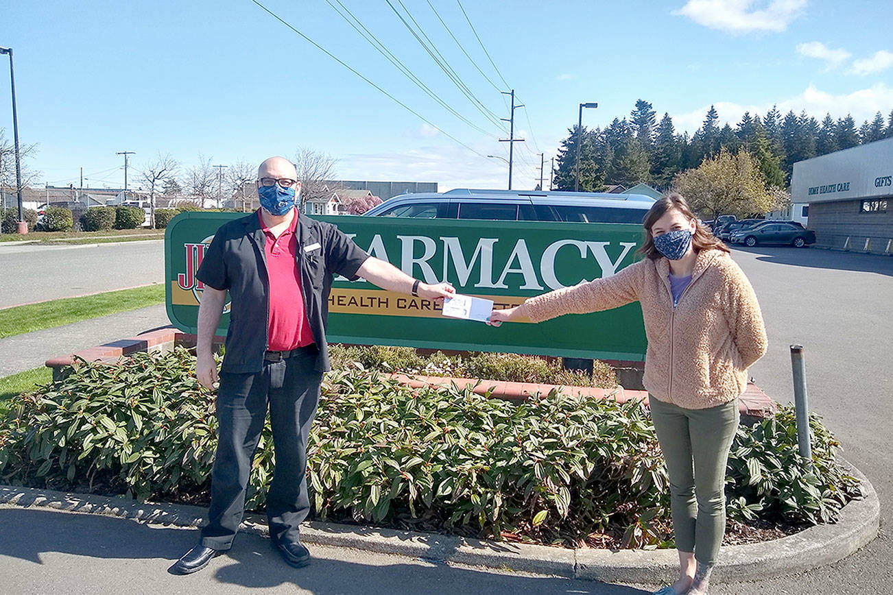 Ryan French, Jim’s home health director, hands a $558.86 check to Hermina Solomon of the Port Angeles Food Bank. The food bank was the January recipient of Jim’s Cares Monthly Charity. The funds are raised through monetary donations, used book sales, donated employee casual days and a percentage of over-the-counter sales at Jim’s.