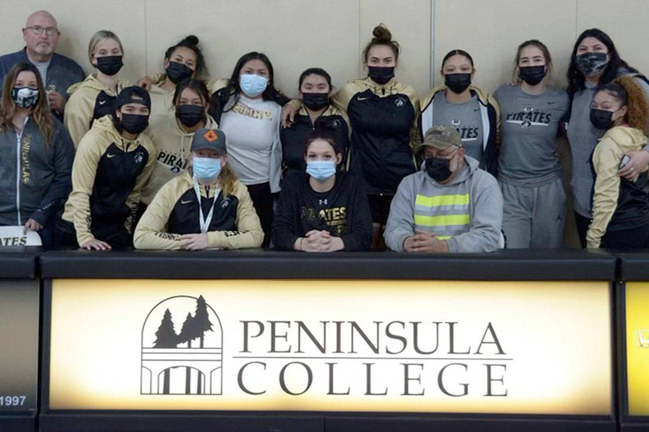 The Peninsula College women's basketball team and coaching staff celebrated the letter of intent signing by Port Angeles senior Madison Cooke, seated center, Friday.