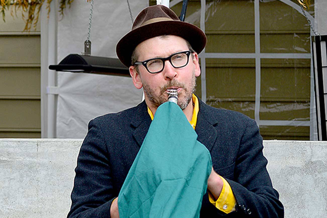 Clarinetist Jonathan Doyle, complete with an aerosol-masking instrument cover, jazzed up the Haller Fountain in downtown Port Townsend in the first “Buskers on the Block” gig. The series will showcase local musicians Thursdays and Saturdays through May. (Diane Urbani de la Paz/Peninsula Daily News)