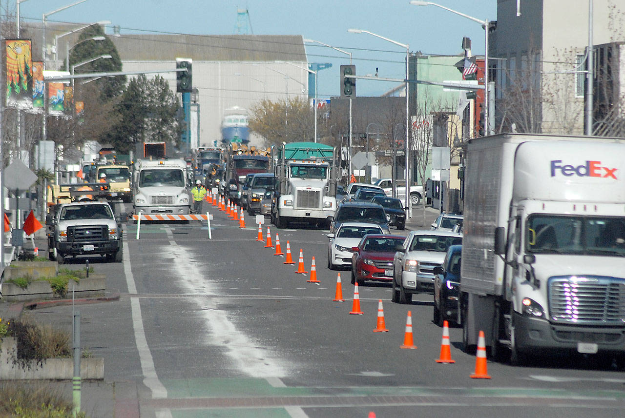 Traffic makes its way along a single lane of First Street in Port Angeles on Wednesday as crews work to improve bicycle lanes through the downtown area. Lines marking the south bike lane were to be repainted from Oak Street to Lincoln Street during the one-day lane closure. (Keith Thorpe/Peninsula Daily News)