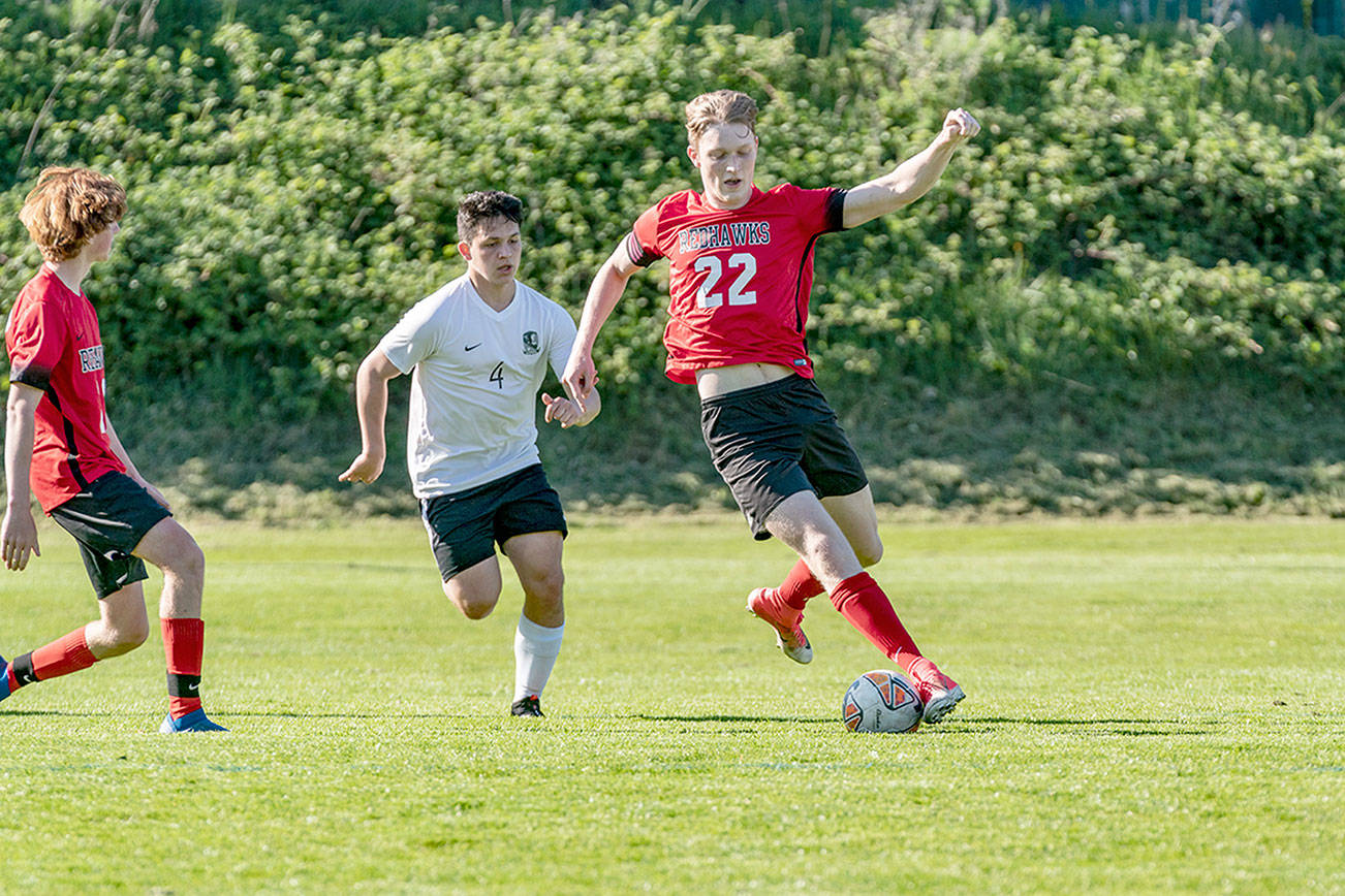 Steve Mullensky/for Peninsula Daily News

East Jefferson's Yarrow Dean, 22, stops the ball and keeps it from Klahowya's Oscar Peterson, 4,  during a Tuesday game at Memorial Field in Port Townsend. East Jefferson's Mark Anderson, left, watches the play unfold.