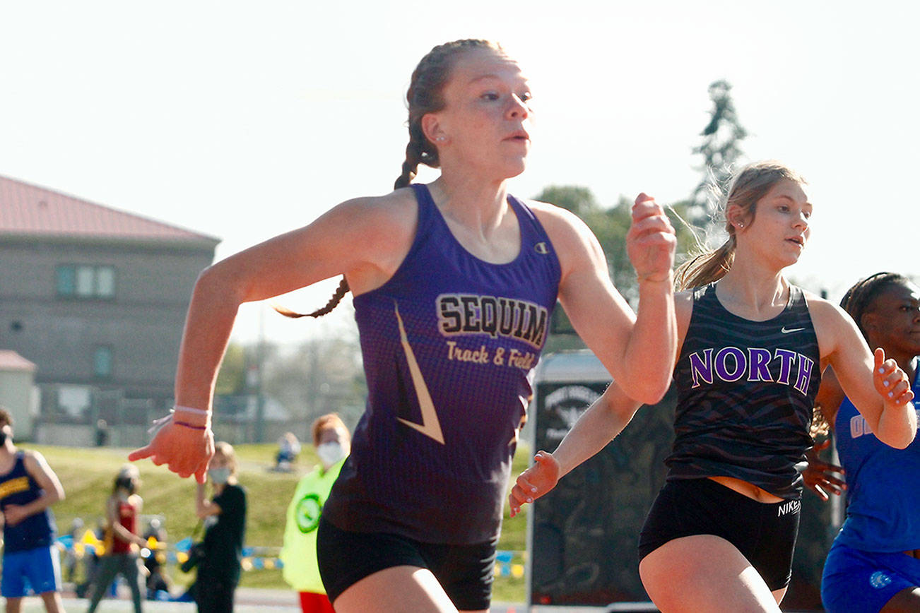 Mark Krulish/Kitsap News Group
Sequim's Riley Pyeatt runs neck-and-neck with Lillian Pruden of North Kitsap in the 100-meter race. She finished second in the 100 but set a school record time in the 400 at the Class 1A/2A/3A Olympic League Championships at Bremerton High School.