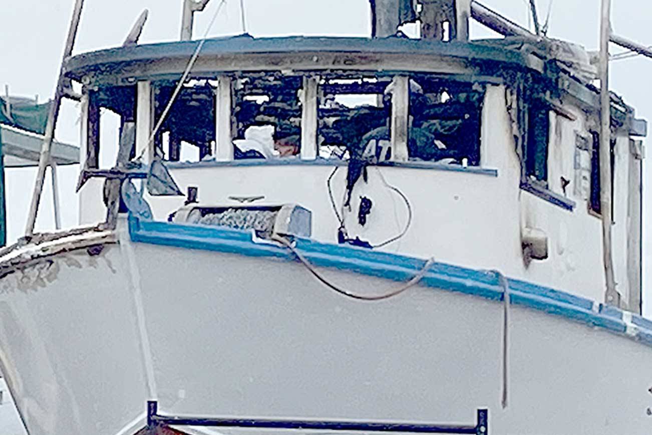 Port Angeles police and the federal Bureau of Alcohol, Tobacco, Firearms and Explosives investigators search the wheelhouse of the Karen L on Sunday. A man was found dead inside the fishing vessel after a fire early Sunday, police said. (Rob Ollikainen/Peninsula Daily News)