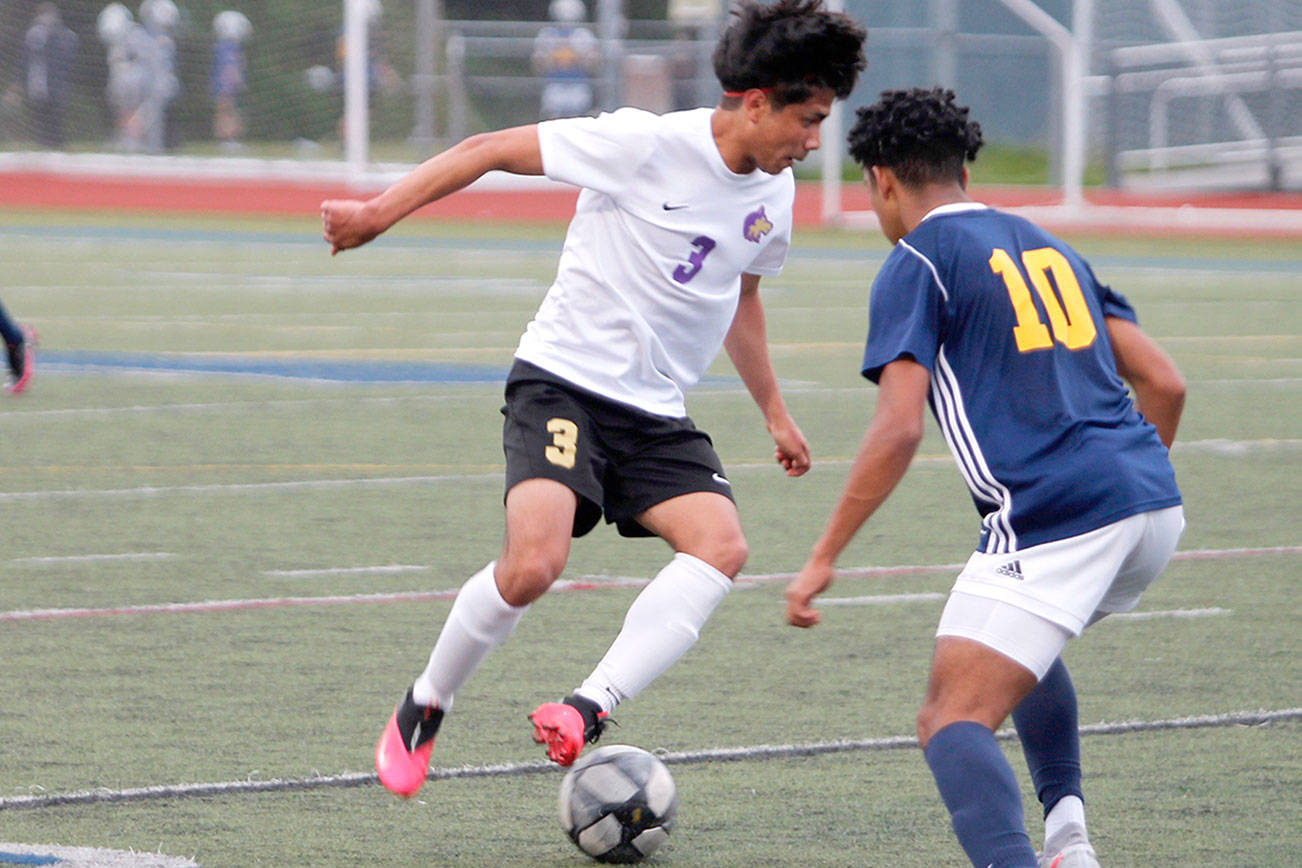 Mark Krulish/Kitsap News Group
Sequim's Christian Gonzales looks to dribble past Bainbridge's Damoni Mckenna-Greenawalt during the Olympic League Boys Soccer Championship.