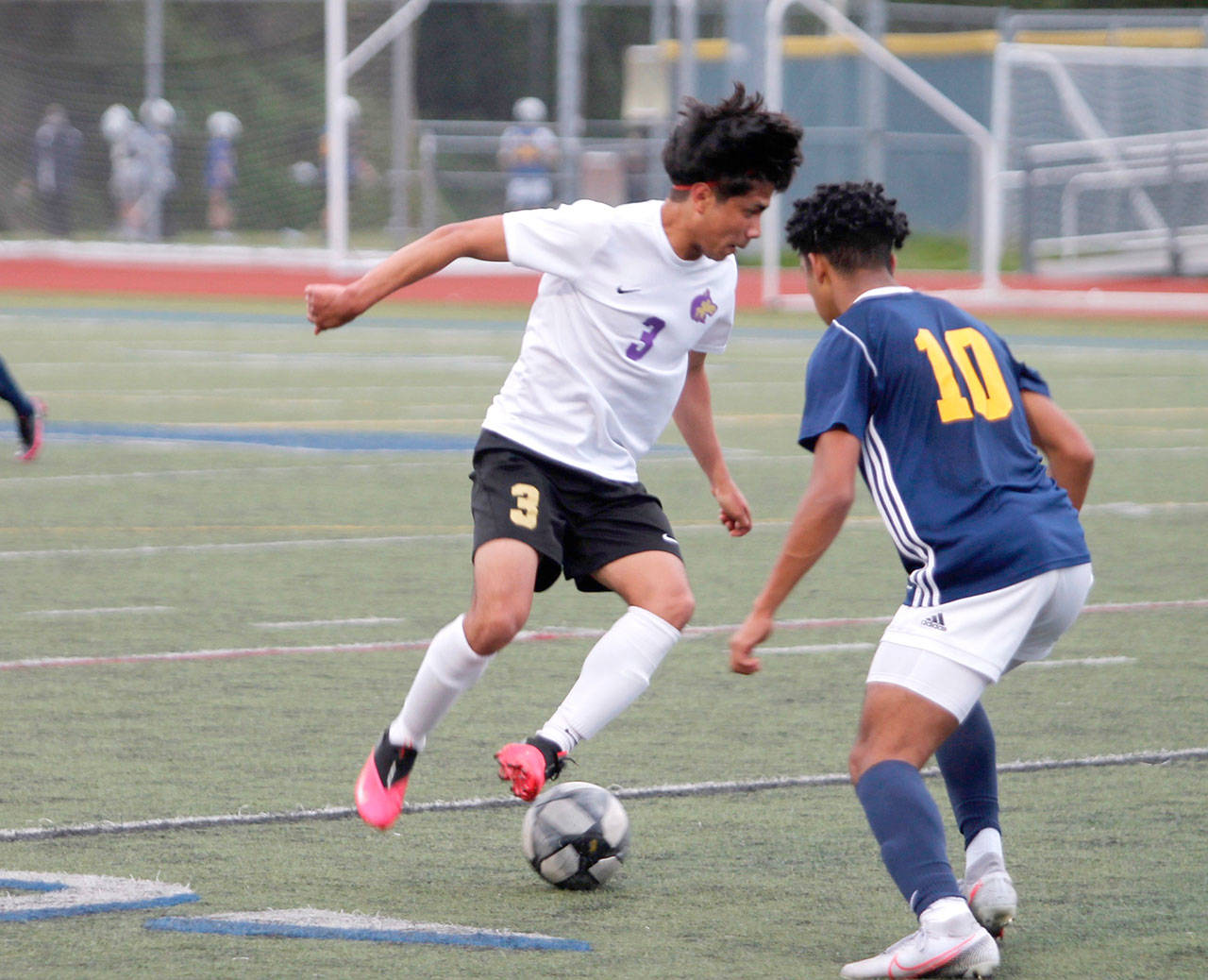 Group Sequim’s Christian Gonzales looks to dribble past Bainbridge’s Damoni Mckenna-Greenawalt during the Olympic League Boys Soccer Championship. (Mark Krulish/Kitsap News Group)