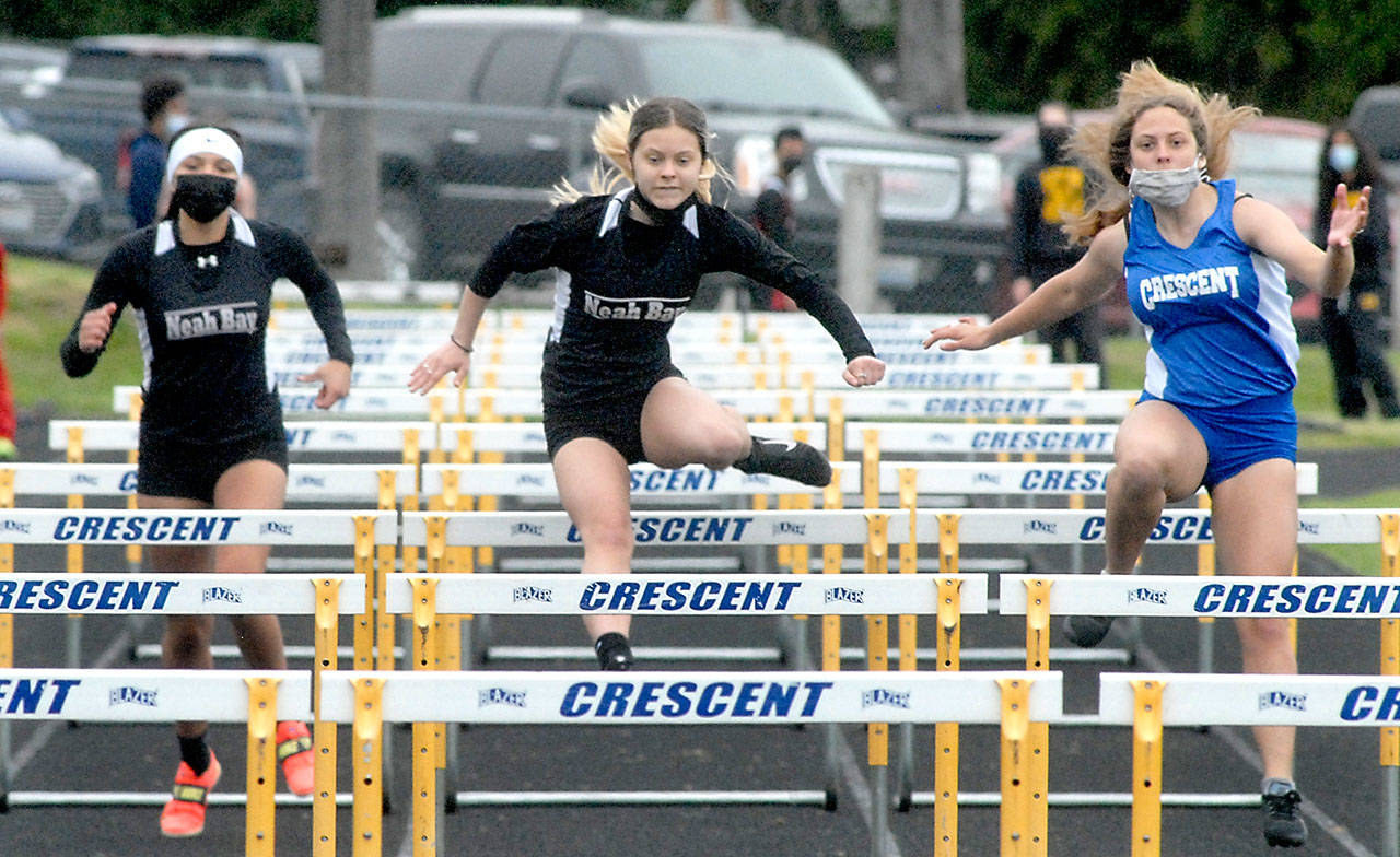 Keith Thorpe/Peninsula Daily News Neah Bay’s Ruth Greene, left, and Kianah Cameron, and Crescent’s JoCy Kazlauskas reace in the 100-meter hurdles on Friday.