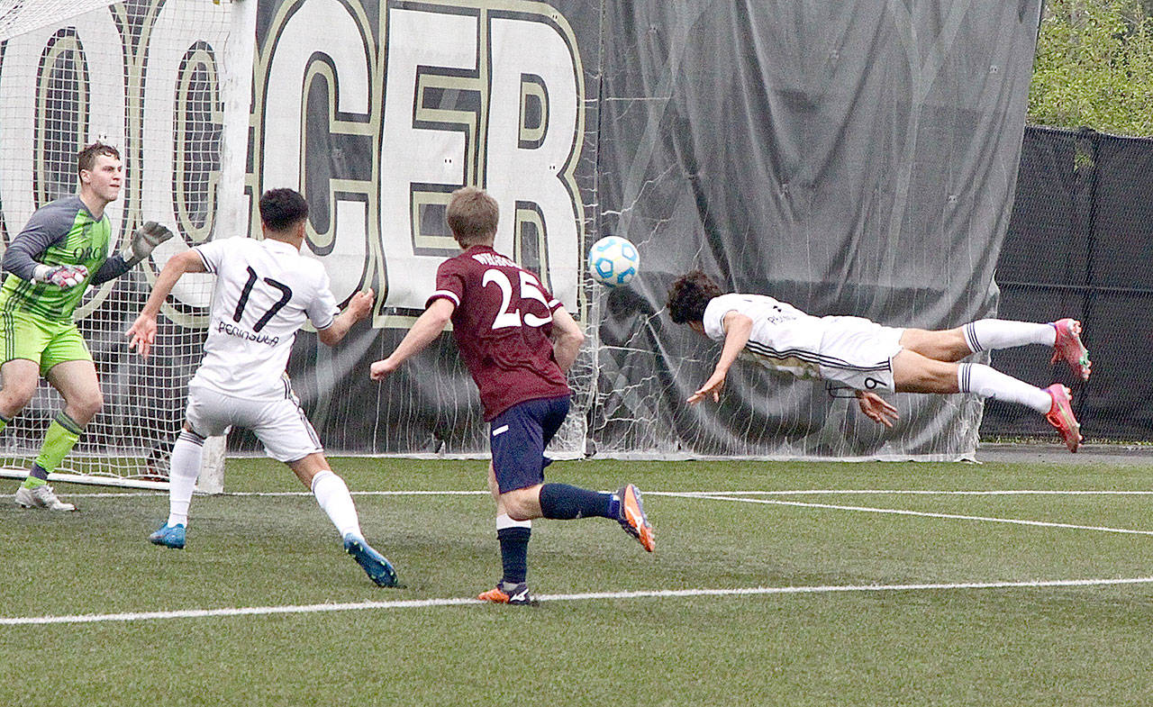 Peninsula College’s Nico Hernandez heads in a goal against Whatcom on Monday afternoon. In on the play is Peninsula’s Fernando Tavares (17). (Dave Logan/for Peninsula Daily News)