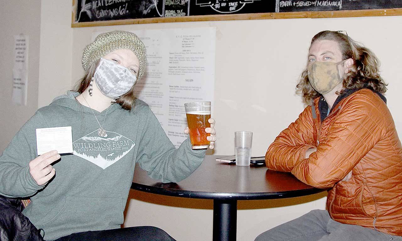 Rachel and Daniel Shyles were among nearly 30 people to attend a COVID-19 popup clinic at Barhop Brewing and Taproom for a free beer to go along with a free vaccine. Rachel got her second shot of Moderna vaccine on Saturday. Daniel said he already had two inoculations. The service was provided by the Clallam County Health and Human Services department. (Dave Logan/for Peninsula Daily News)