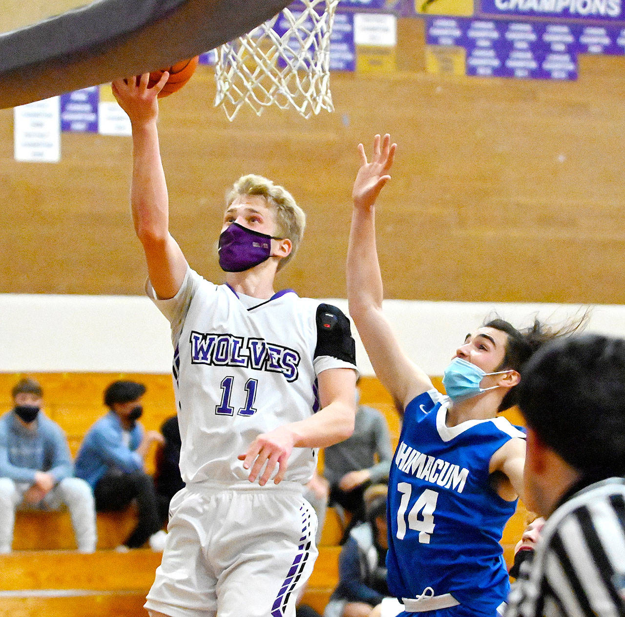 Sequim’s Erik Christiansen goes up for a layup past East Jefferson’s Lonnie Kenney in Monday night’s game in Sequim. (Michael Dashiell/Olympic Peninsula News Group)