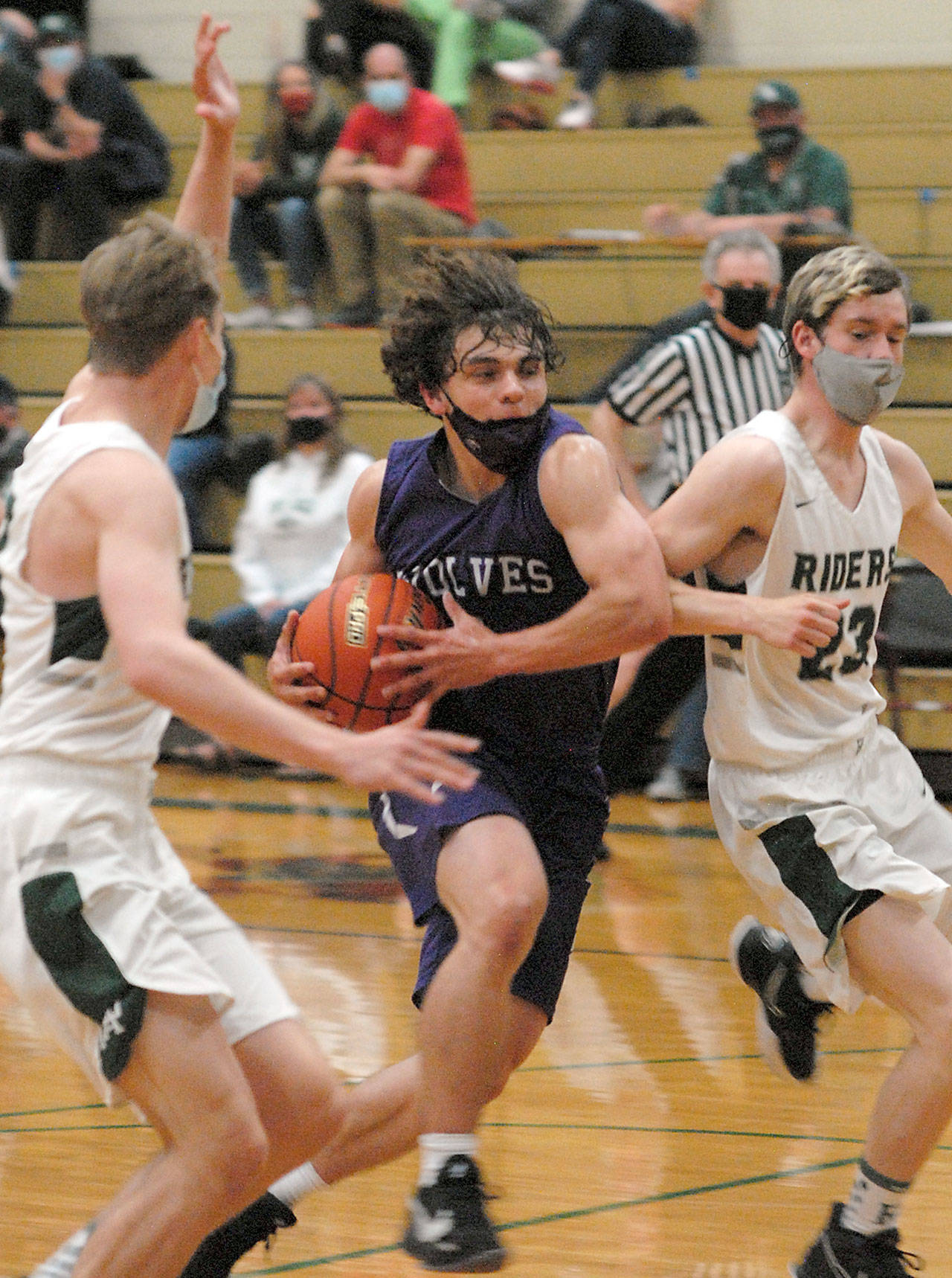 Sequim’s Tyler Mooney, center, drives to the lane flanked by Port Angeles’ Tanner Price, left, and Michael Soule on Wednesday night in Port Angeles. (Keith Thorpe/Peninsula Daily News)